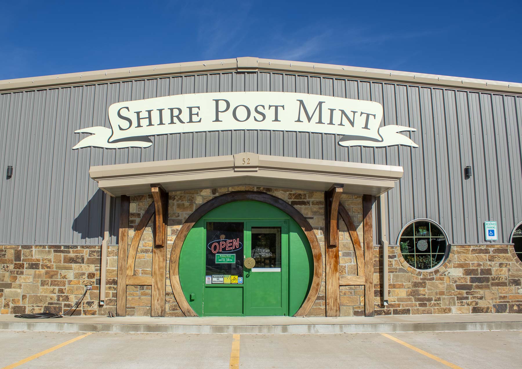 Big green hobbit door entrance of Shire Post Mint, a fantasy coin mint and gift shop in Arkansas